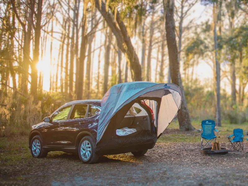 Couple camping in with their Napier Sportz Cove attached to their SUV. 