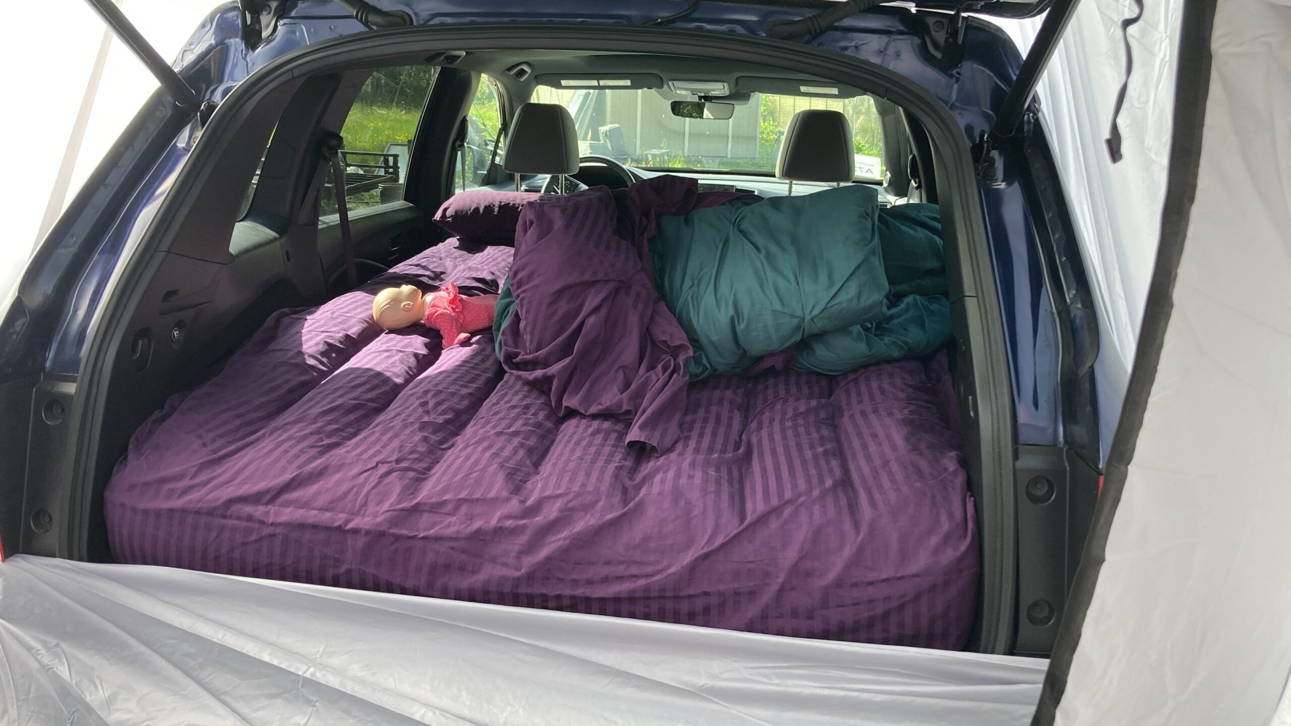 From inside the tent, the bed made up in the Passport cargo area